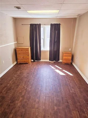 a view of an empty room with closet and a window