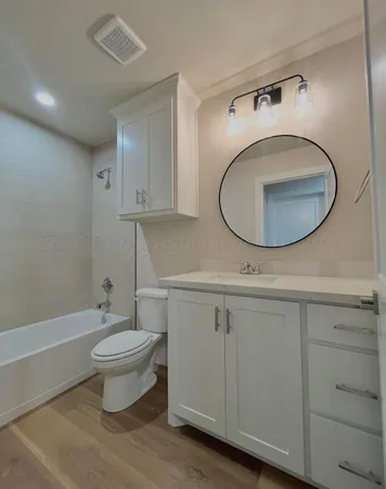 a bathroom with a toilet a sink and mirror