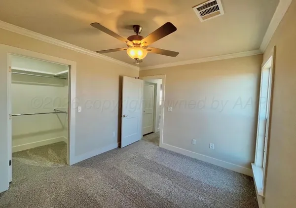 a view of an empty room with a ceiling fan