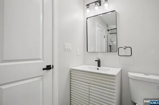 a bathroom with a sink a toilet and a mirror