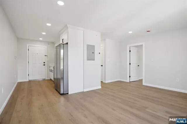 a view of an empty room with wooden floor