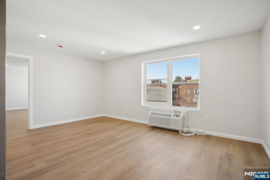 200-202 Summer Street, Unit 3 Paterson, NJ 07501 - Photo 5 of 12 an empty room with wooden floor and windows