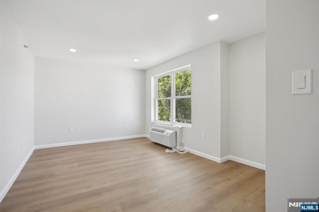 200-202 Summer Street, Unit 3 Paterson, NJ 07501 - Photo 8 of 12 an empty room with wooden floor and windows