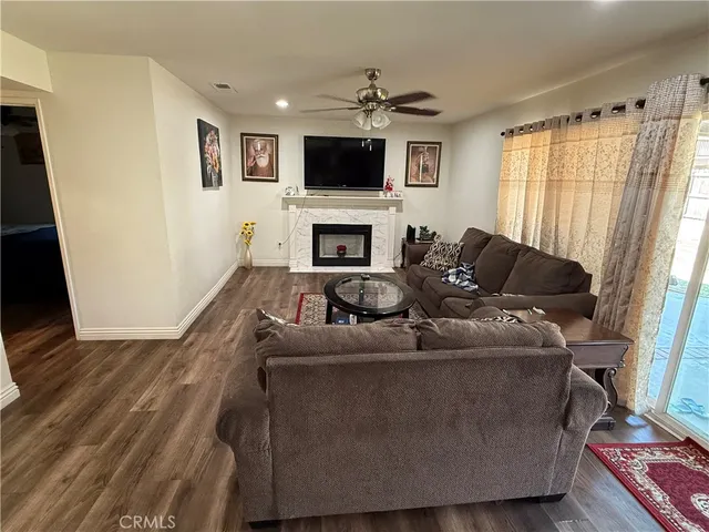 a living room with furniture a flat screen tv and a fireplace