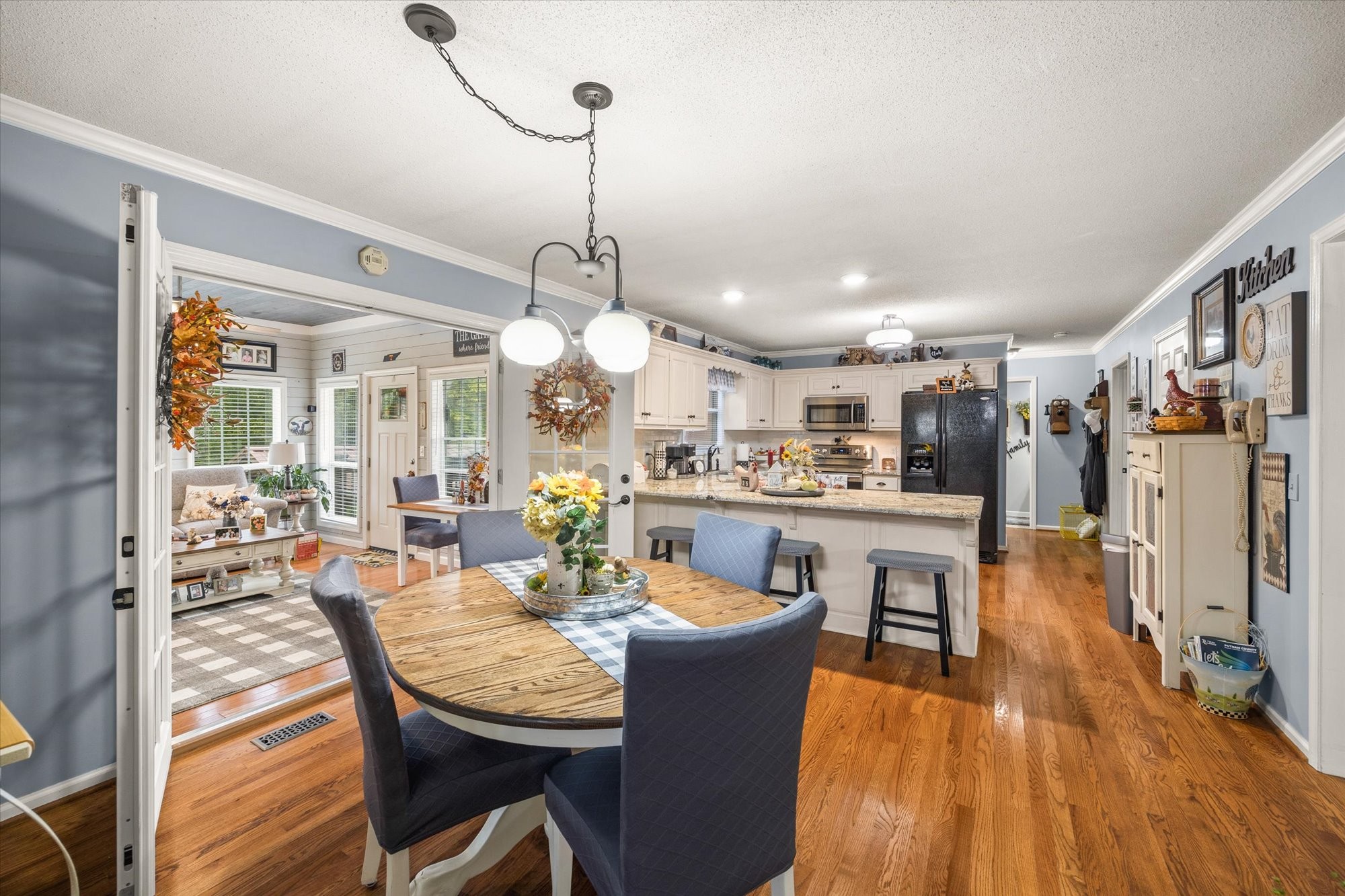 7214 Sarah Thomas Road Silver Point, TN 38582 - Photo 11 of 52 a view of a dining room and livingroom with furniture wooden floor a chandelier