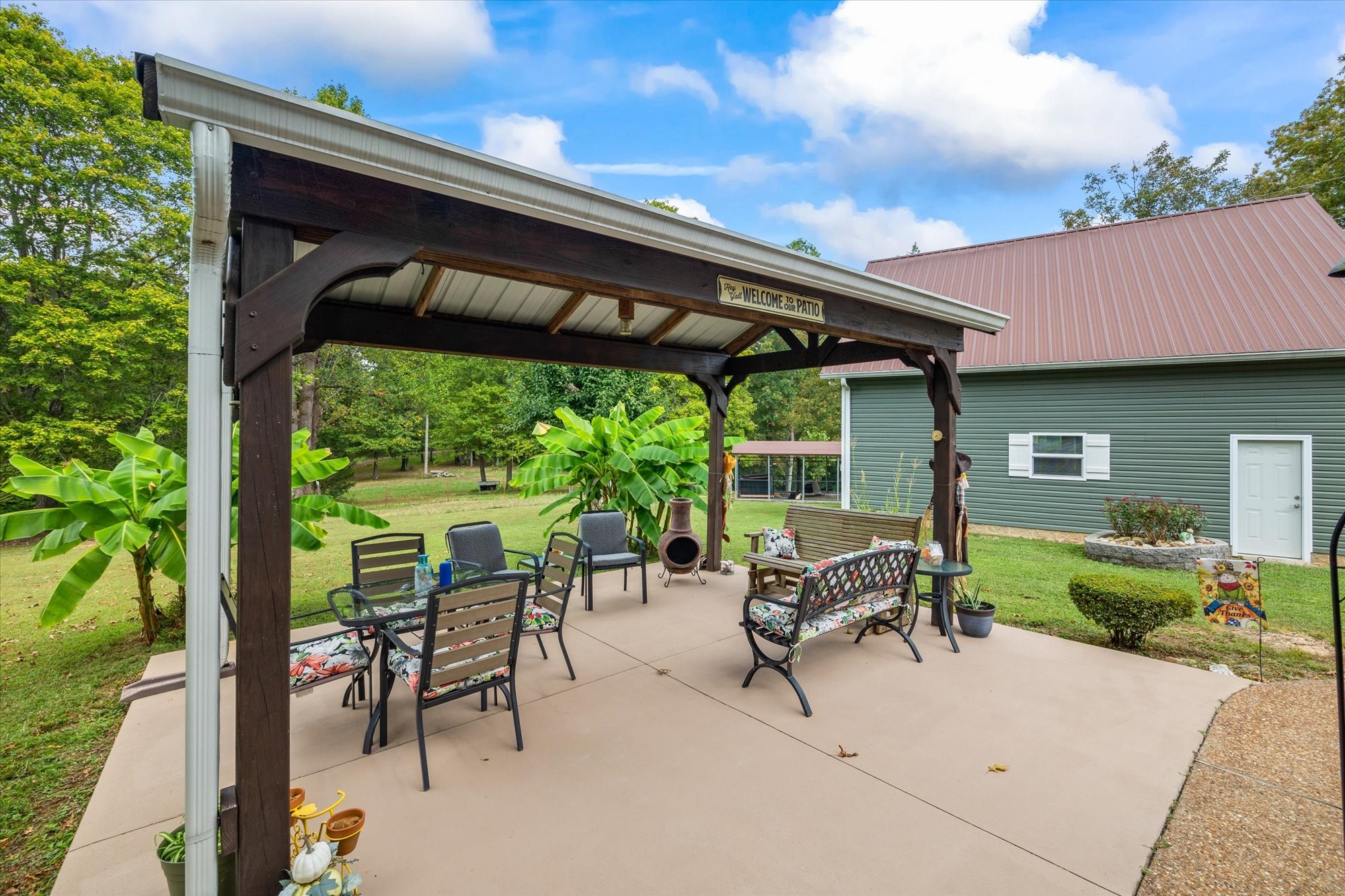 7214 Sarah Thomas Road Silver Point, TN 38582 - Photo 3 of 52 a view of patio with table and chairs under an umbrella with a small yard