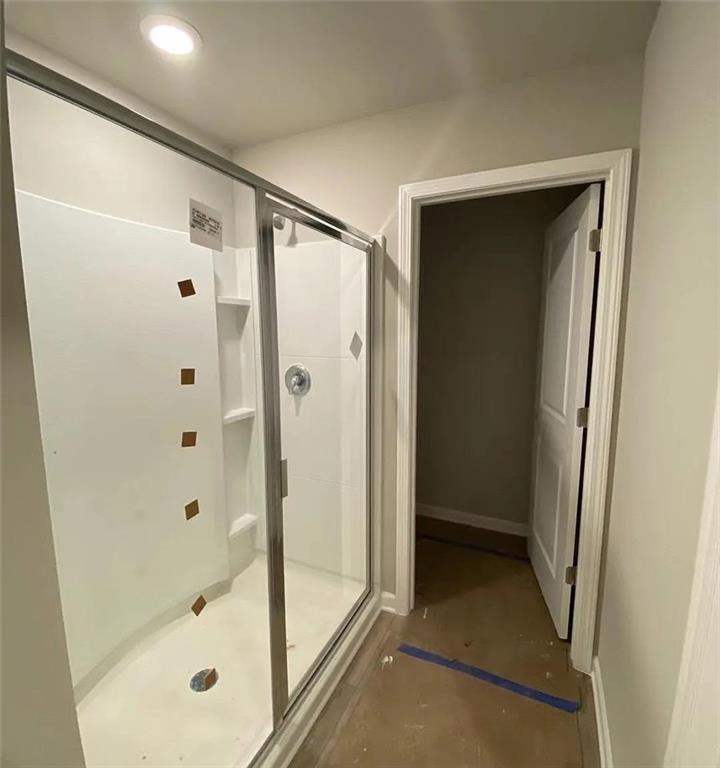 115 Wynn Way Pendergrass, GA 30567 - Photo 16 of 22 a bathroom with a shower and a glass door
