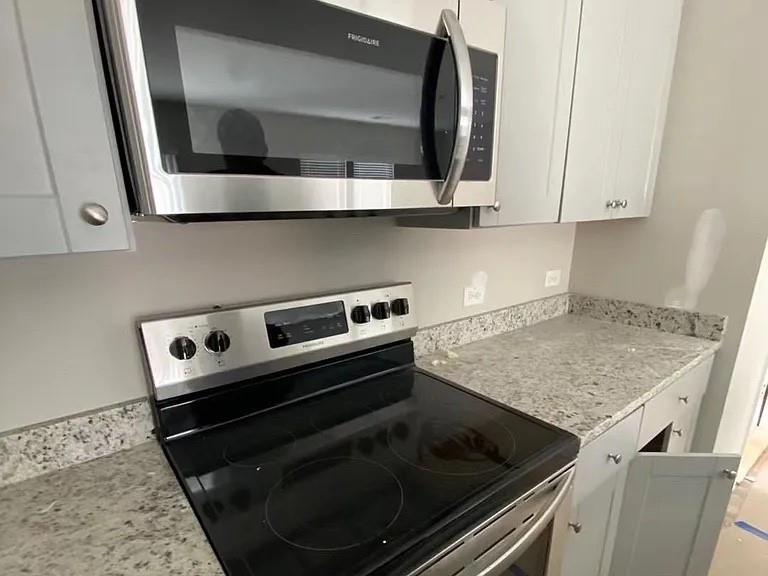 115 Wynn Way Pendergrass, GA 30567 - Photo 7 of 22 a kitchen with a stove and a microwave