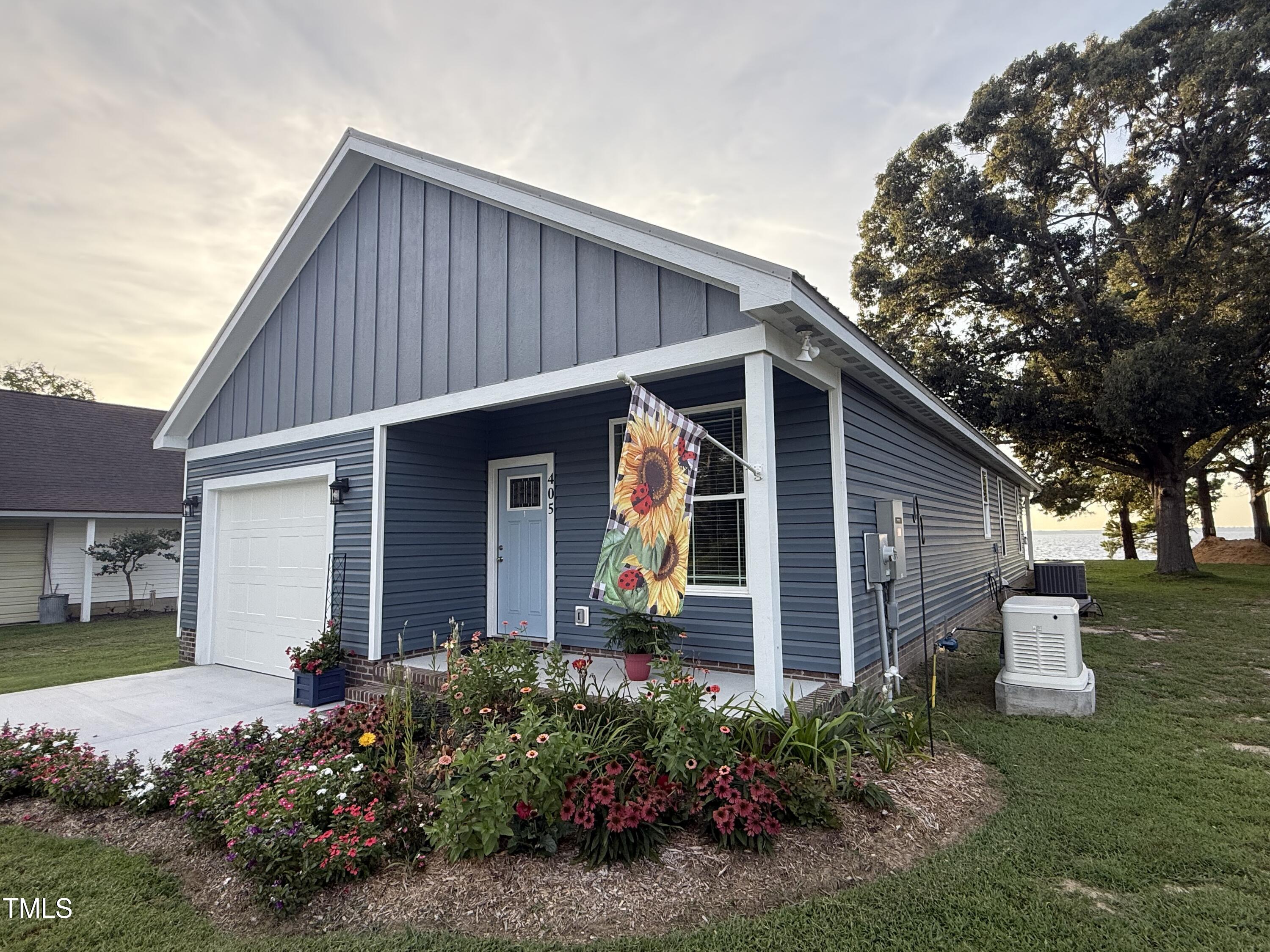 a view of a house with wooden walls and flower plants