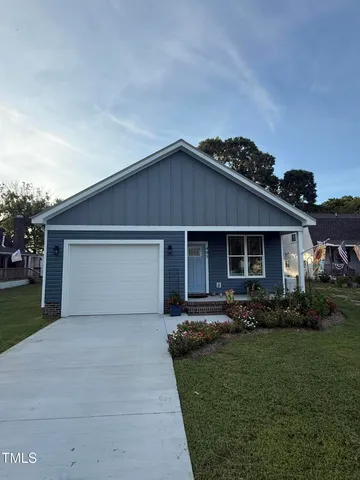 a front view of house with a garden