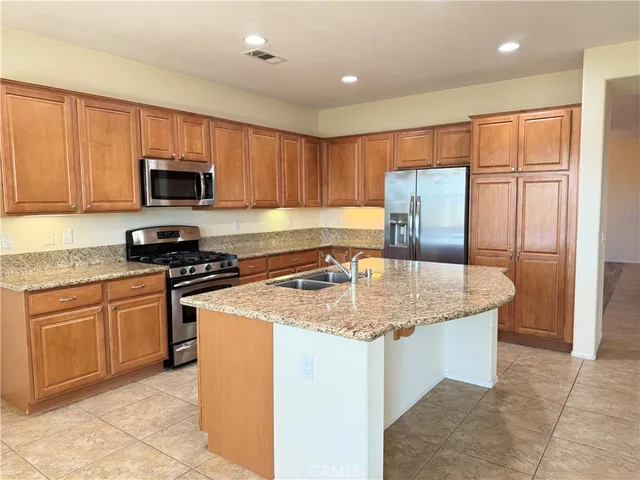 a kitchen with stainless steel appliances granite countertop a stove sink microwave and refrigerator