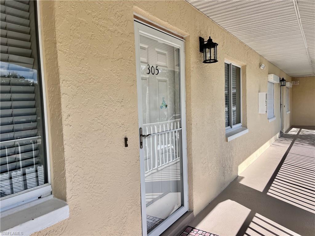 3685 Amberly Circle, Unit D305 Naples, FL 34112 - Photo 17 of 42 a view of a hallway with wooden floor and staircase