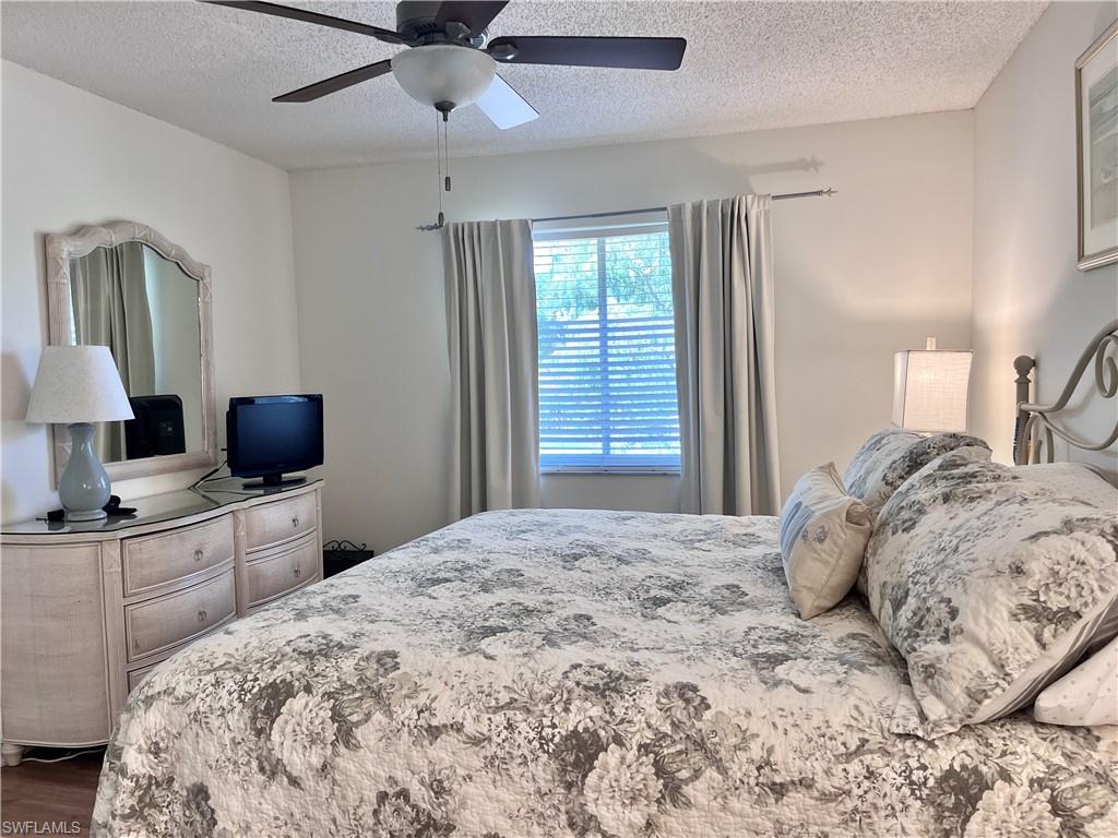 3685 Amberly Circle, Unit D305 Naples, FL 34112 - Photo 9 of 42 a bedroom with a bed and a flat screen tv