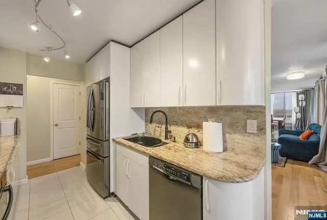 a kitchen with stainless steel appliances granite countertop a sink and a refrigerator