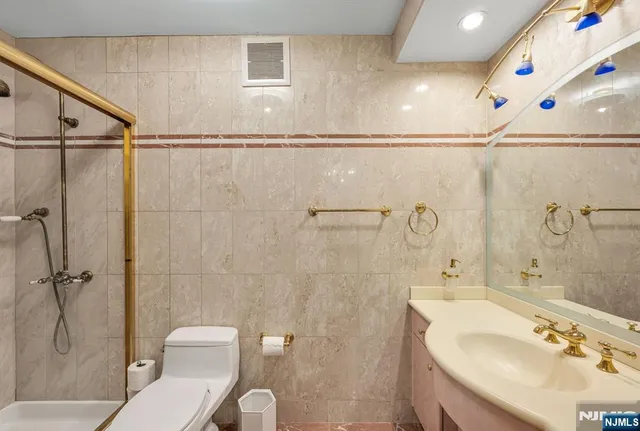 a bathroom with a sink a toilet and shower