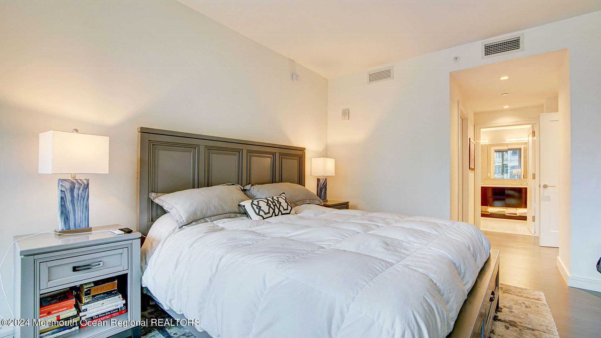 15 Morris Avenue, Unit 307 Long Branch, NJ 07740 - Photo 22 of 33 a bedroom with a bed and a lamp on dresser