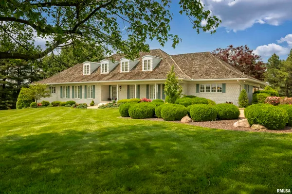 a view of a house with a yard and potted plants