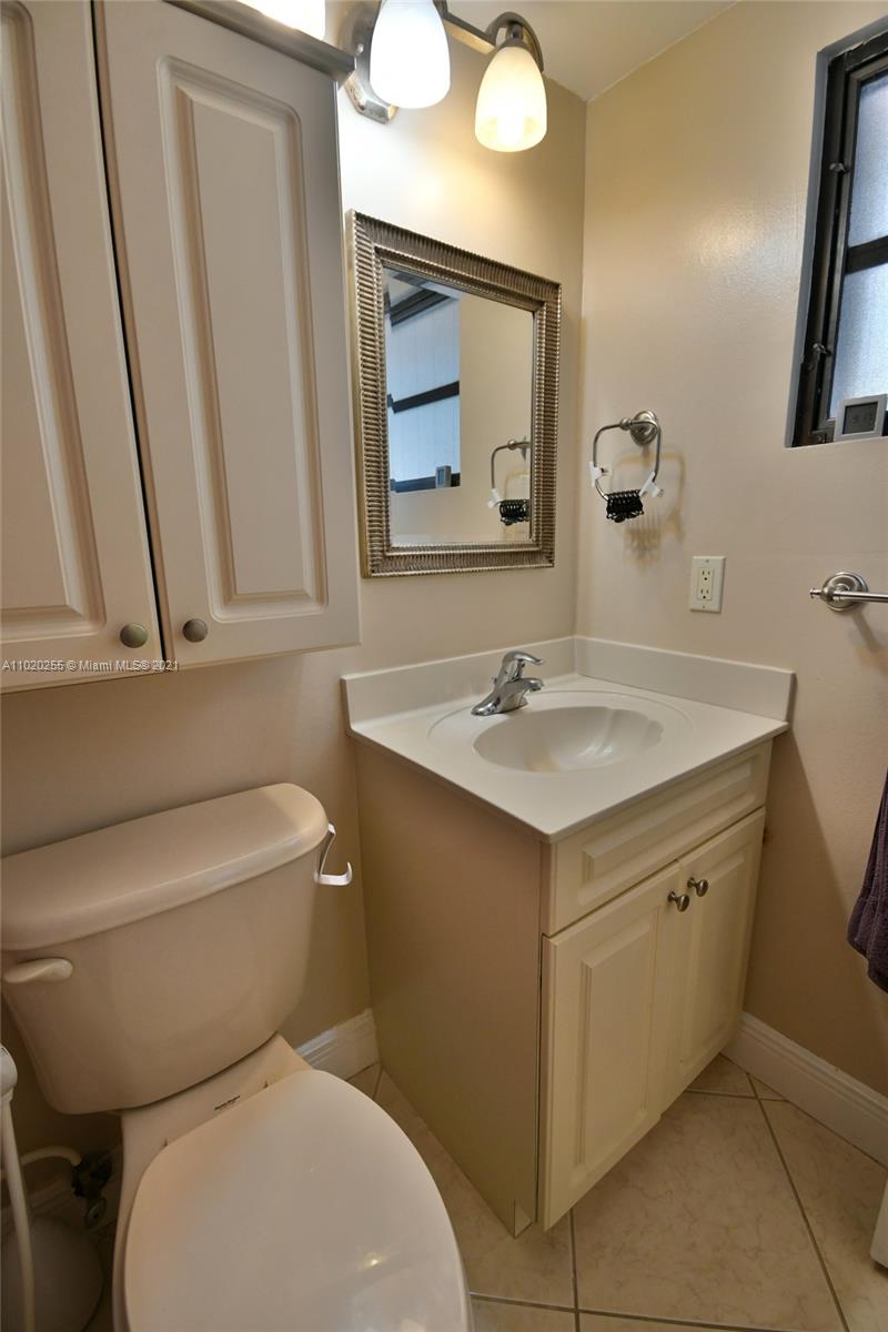 3141 Southwest 27th Terrace, Unit B Miami, FL 33133 - Photo 13 of 15 a bathroom with a toilet sink and mirror