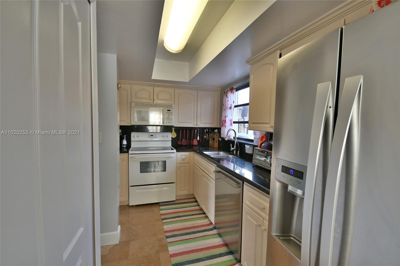 3141 Southwest 27th Terrace, Unit B Miami, FL 33133 - Photo 5 of 15 a kitchen with cabinets and stainless steel appliances