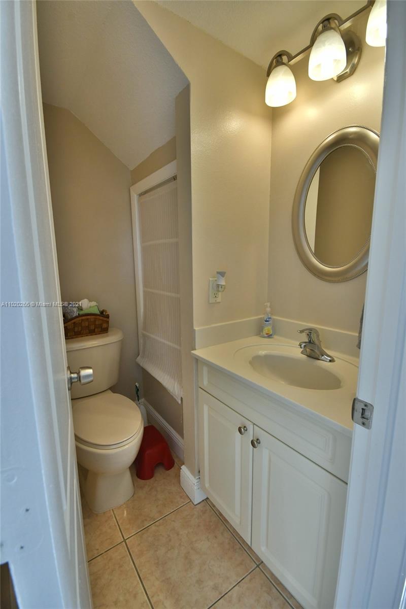 3141 Southwest 27th Terrace, Unit B Miami, FL 33133 - Photo 7 of 15 a bathroom with a granite countertop toilet sink and mirror