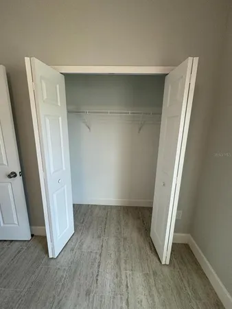 an empty room with wooden floor and a window