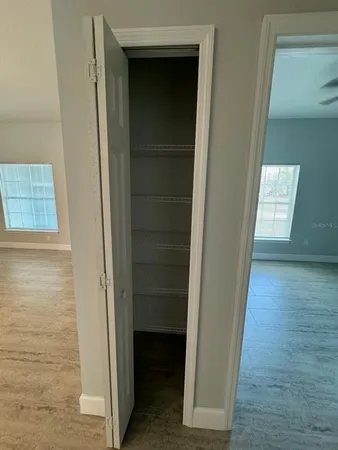 a view of hallway with closet and wooden floor