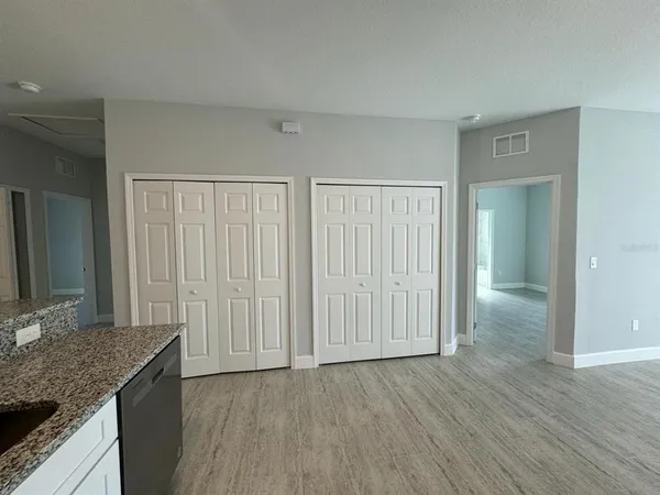 an empty room with wooden floor and a bathroom
