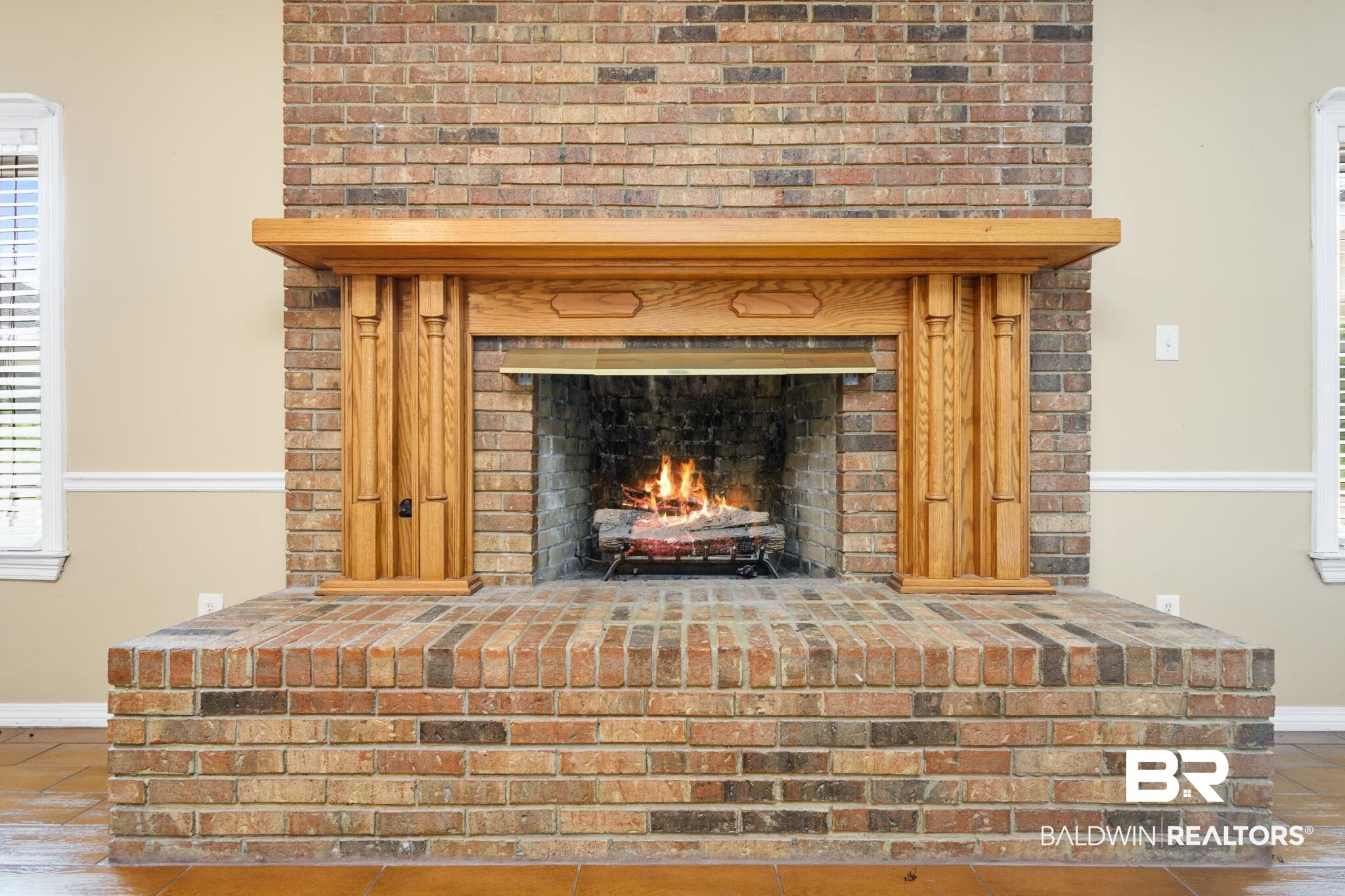 7540 2 Mile Road Irvington, AL 36544 - Photo 45 of 82 Brick fireplace featuring a raised hearth and a wood-finish mantel