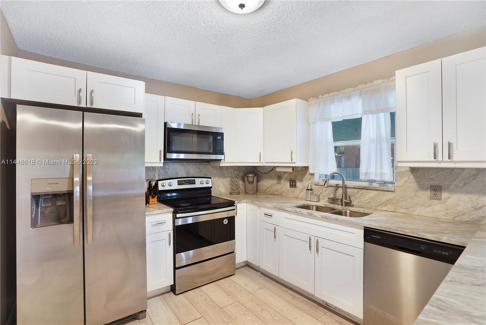1330 Sesame Street Opa-Locka, FL 33054 - Photo 11 of 27 a kitchen with a sink stainless steel appliances and cabinets