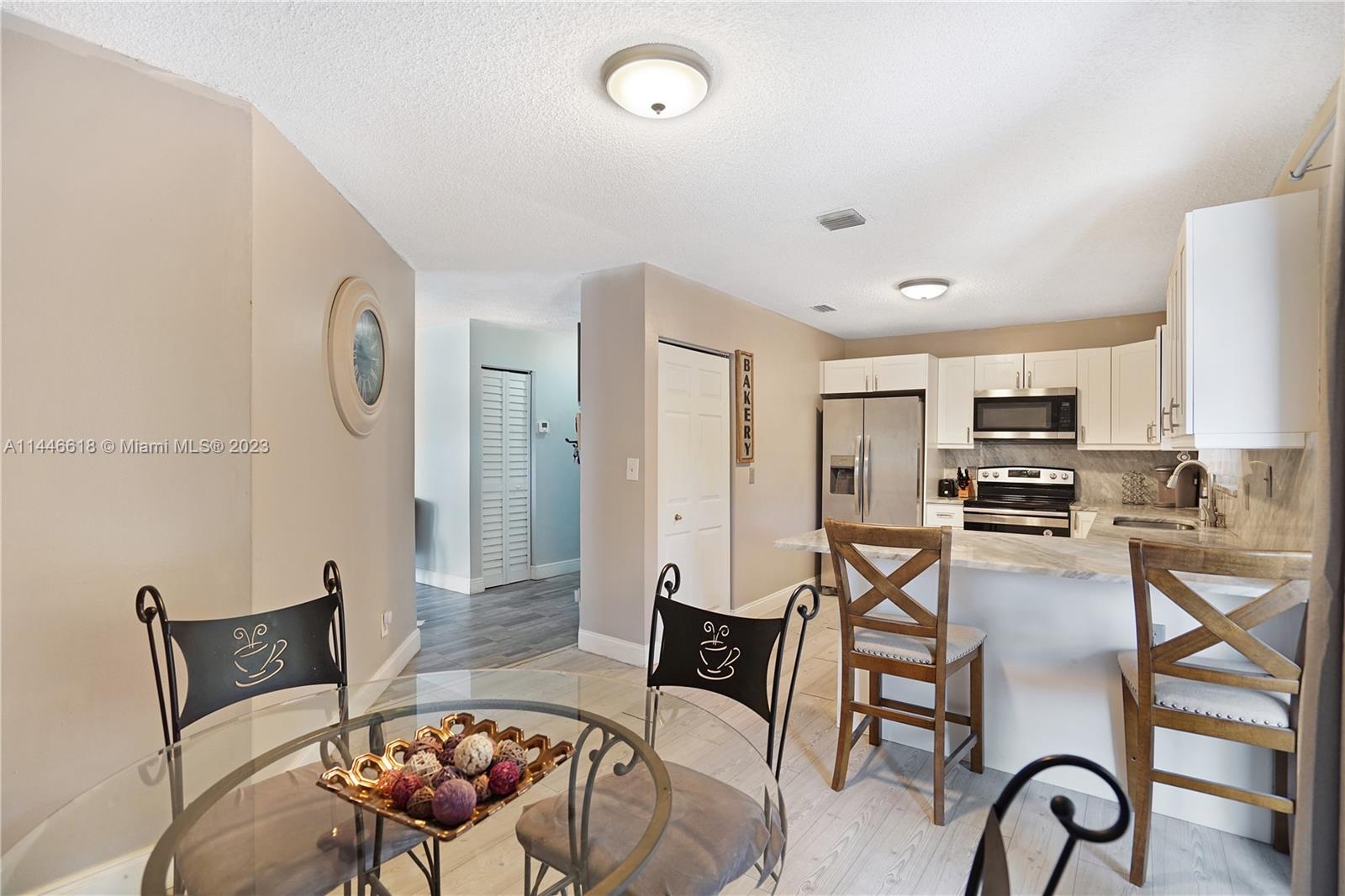 1330 Sesame Street Opa-Locka, FL 33054 - Photo 8 of 27 a living room with furniture a flat screen tv and kitchen view