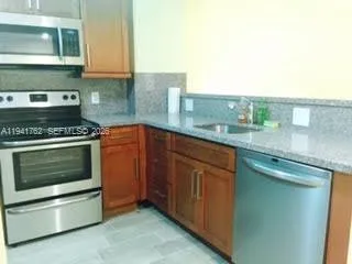 a kitchen with granite countertop wooden cabinets and stainless steel appliances