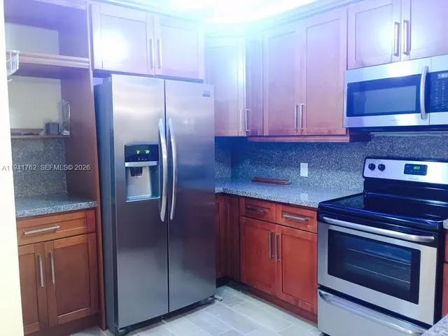 a kitchen with a refrigerator and a microwave
