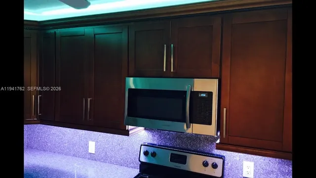 an empty room with kitchen view and a projector