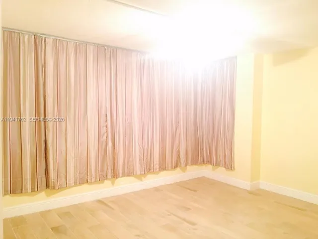 a view of wooden floor and a curtain