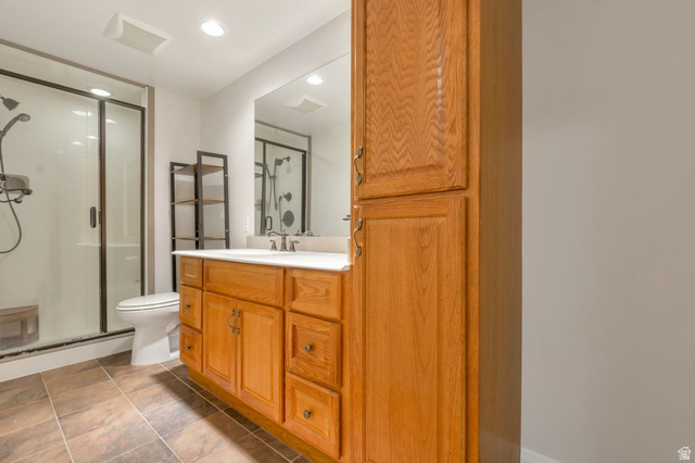 1092 Tithing Ridge Drive Riverton, UT 84065 - Photo 22 of 25 Bathroom featuring a wood vanity with a white countertop, large mirror, tile flooring, and a glass-enclosed shower