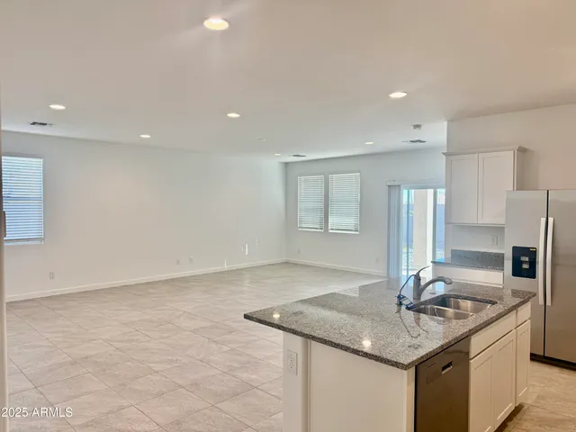 a kitchen with stainless steel appliances granite countertop a sink a stove and a refrigerator