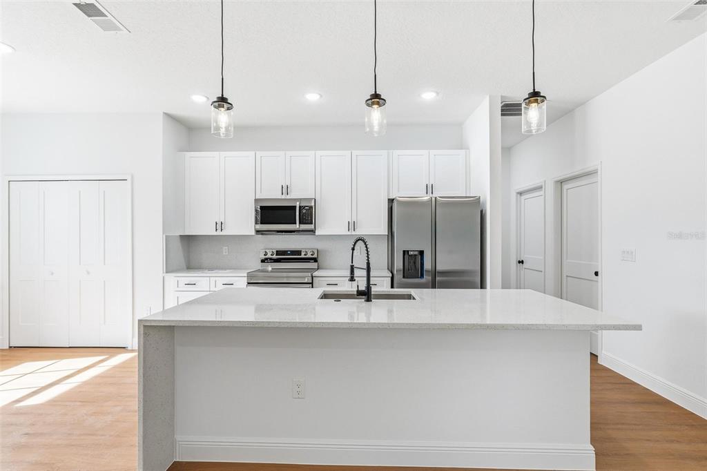 5227 Southwest 165th St Road Ocala, FL 34473 - Photo 12 of 37 a kitchen with stainless steel appliances kitchen island a refrigerator sink and cabinets