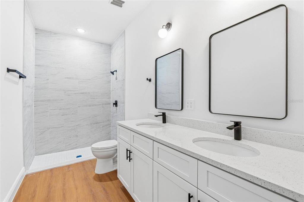 5227 Southwest 165th St Road Ocala, FL 34473 - Photo 21 of 37 a bathroom with a double vanity sink toilet and shower