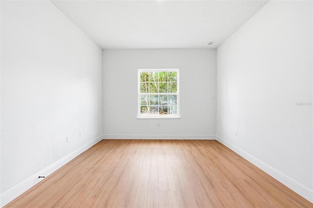 5227 Southwest 165th St Road Ocala, FL 34473 - Photo 23 of 37 an empty room with wooden floor and windows
