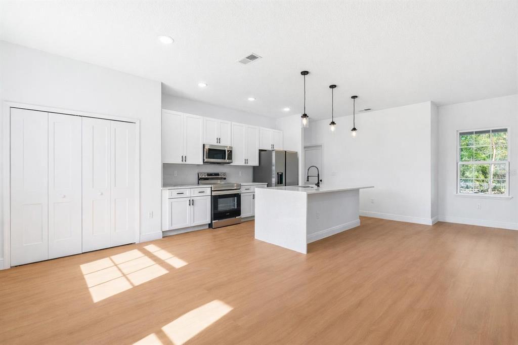 5227 Southwest 165th St Road Ocala, FL 34473 - Photo 8 of 37 a large white kitchen with cabinets