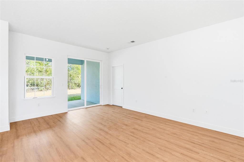 5227 Southwest 165th St Road Ocala, FL 34473 - Photo 10 of 37 an empty room with wooden floor and windows