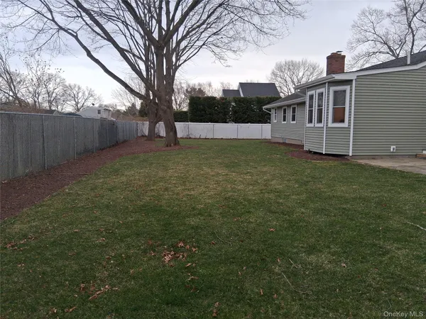 a view of a house with backyard and trees