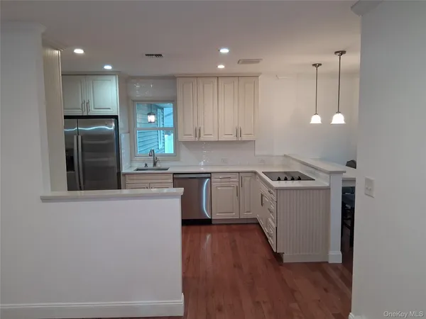 a kitchen with granite countertop a sink cabinets and stainless steel appliances