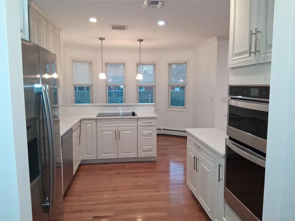 a kitchen with white cabinets and stainless steel appliances