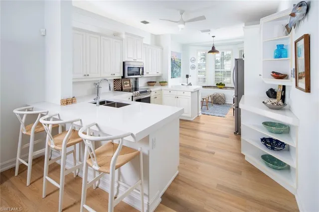 a large white kitchen with lots of counter space and wooden floor