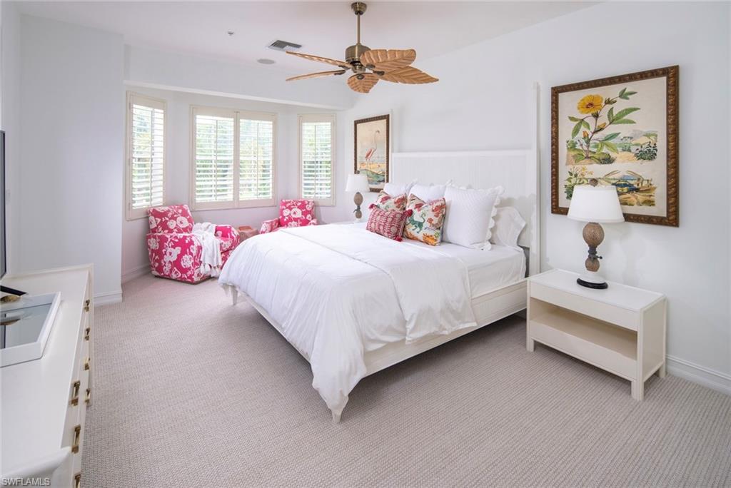 846 9th Avenue South, Unit 104 Naples, FL 34102 - Photo 7 of 11 a bedroom with a bed chandelier painting on the wall and a window