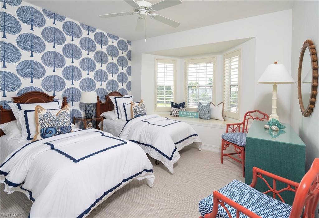 846 9th Avenue South, Unit 104 Naples, FL 34102 - Photo 9 of 11 a bedroom with two beds and a chandelier