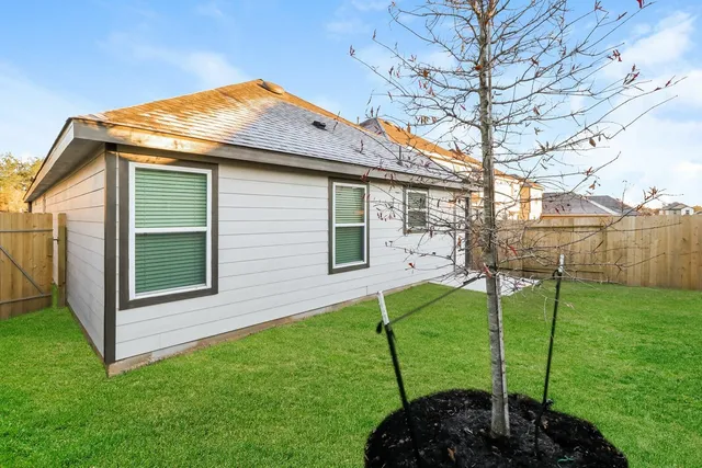 a backyard of a house with potted plants and a bench