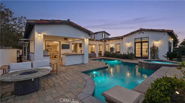 a view of a house with pool table chairs and a yard