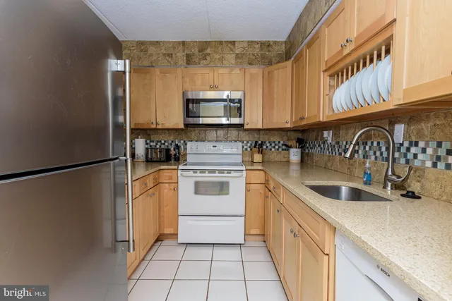 a kitchen with granite countertop white cabinets and white appliances
